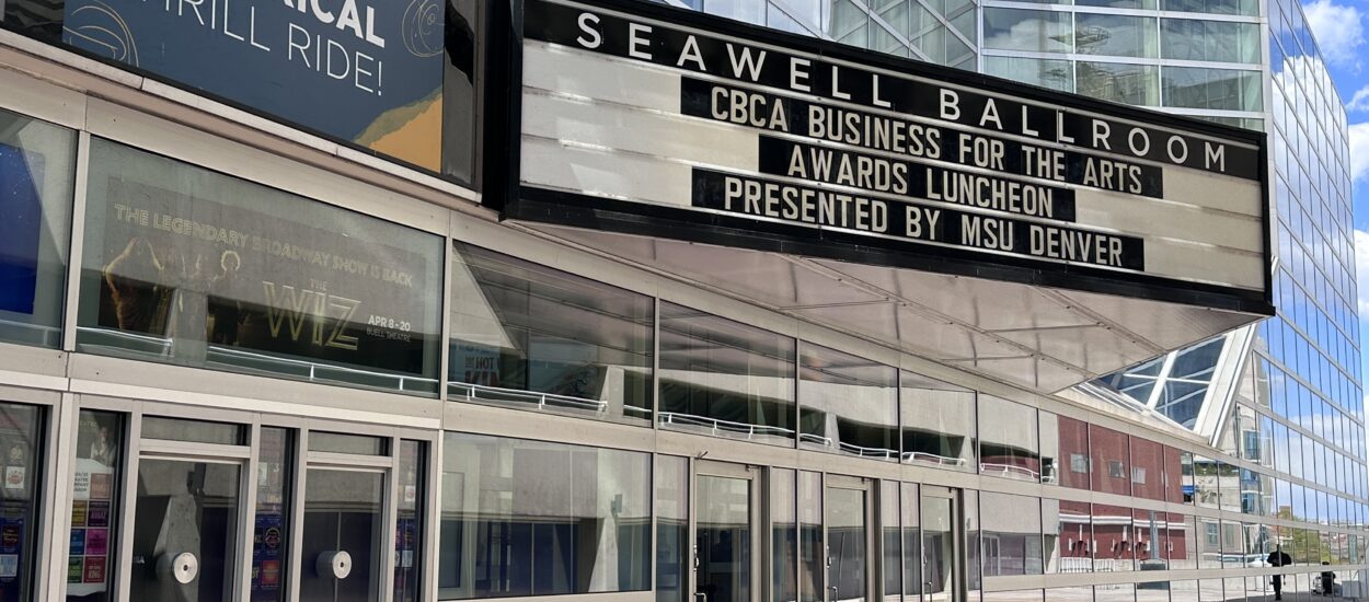 Marquee outside Seawell Ballroom advertises "CBCA Business for the Arts Awards Luncheon presented by MSU Denver." Modern glass building and a sign reading "Join the Theatrical Thrill Ride!" are also visible.